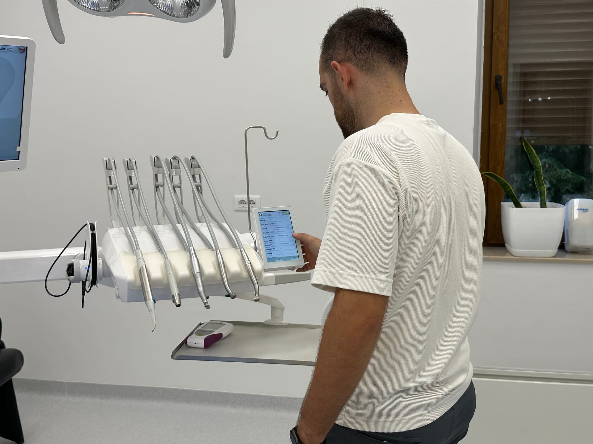 Engineer Erion Çollaku checking settings in a dental chair's service menu